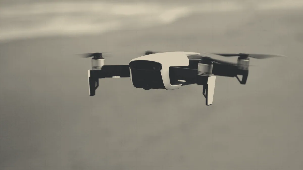 A camera drone in the air above a coastline.