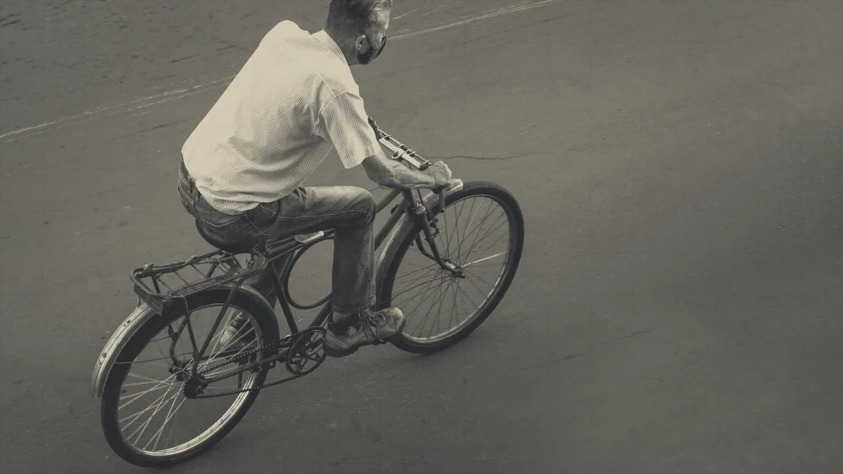 A rider on a road, seen from above.