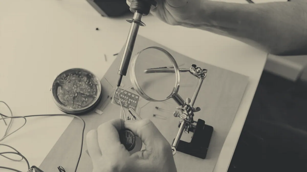 A soldering iron at work on a small board.